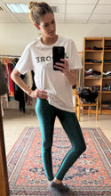 Cargar imagen en el visor de la galería, Modelo con legging lycra verde turquesa metalizada tiro alto, vista lateral fondo beige