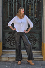 Cargar imagen en el visor de la galería, Mujer usando pantalón cuerina negro tiro alto de calce ancho elegante – Fran del Solar