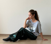 Cargar imagen en el visor de la galería, Mujer usando pantalón Sofía verde metalizado tiro alto de calce ancho elegante – Fran del Solar