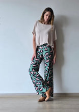 Cargar imagen en el visor de la galería, Pantalón de lycra animal print verde tiro alto, modelo de pie mostrando calce suelto