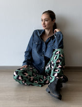 Cargar imagen en el visor de la galería, Pantalón animal print verde de lycra tiro alto, modelo sentada mostrando pretina ancha
