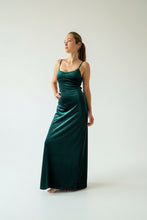 Cargar imagen en el visor de la galería, Vestido largo verde botella con tirantes, caída elegante y brillo sutil bajo luz natural.
